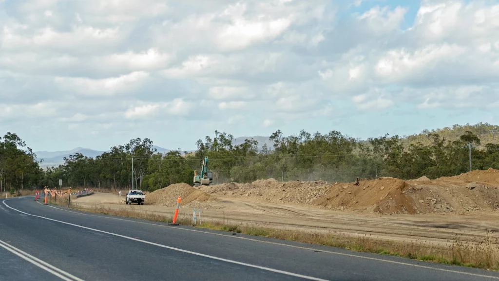 Under construction road featuring heavy equipment & a truck | Sewell Sewell Beard LLC