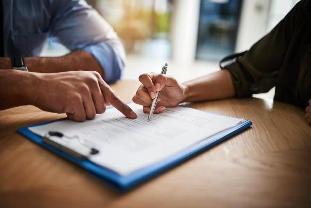 A couple collaboratively signing a contract | Sewell Sewell Beard LLC