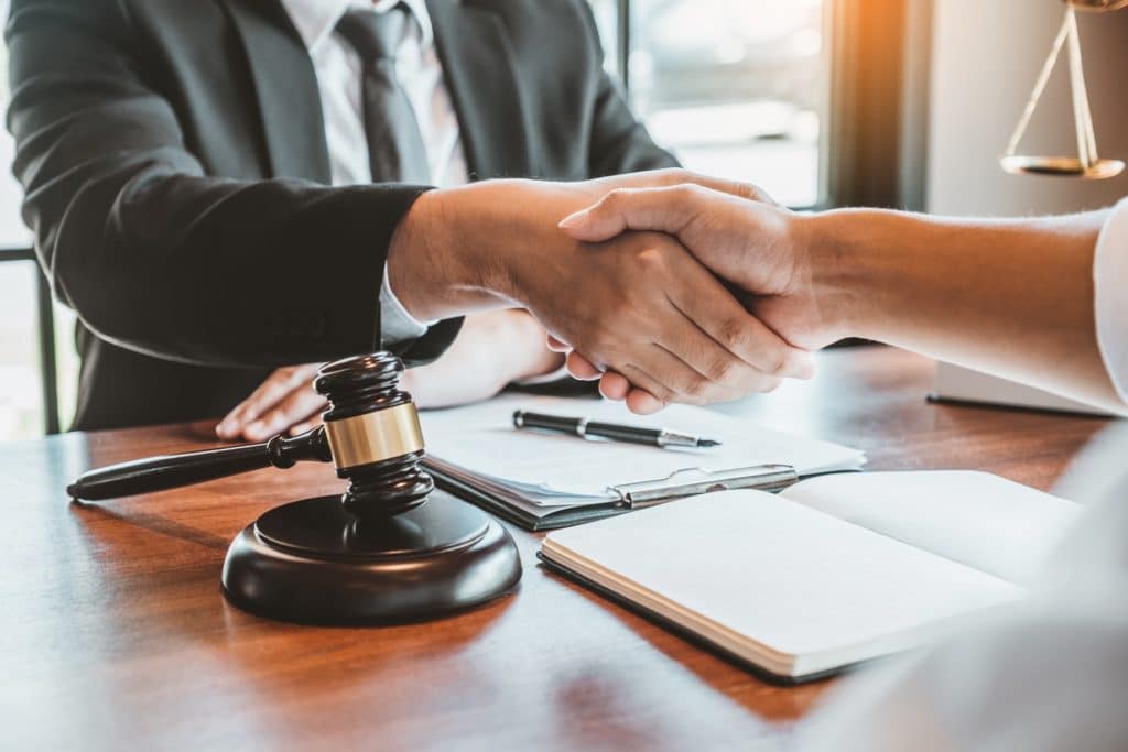 A lawyer and client shake hands in an office | Sewell Sewell Beard LLC