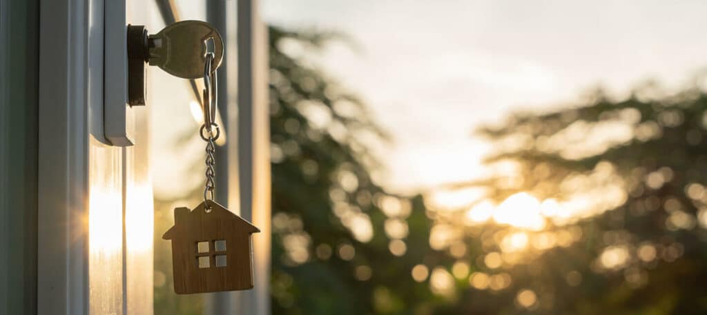 A key hangs from a door, silhouetted against a vibrant sunset | Sewell Sewell Beard LLC