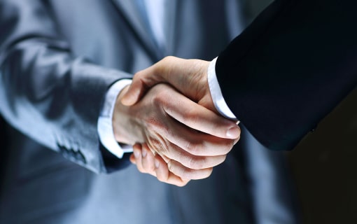 Two businessmen in suits shaking hands